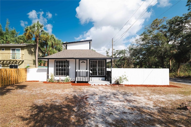 view of front of property with a shingled roof and fence