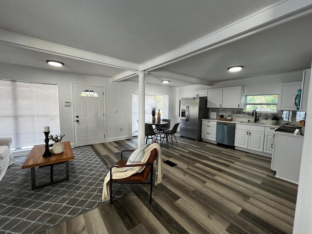 1397 43rd St, Sarasota, FL 34234 - living room featuring dark wood-style flooring, decorative columns, and beam ceiling