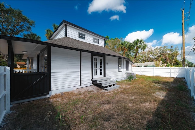 1397 43rd St, Sarasota, FL 34234 - back of house featuring french doors, a fenced backyard, and a shingled roof