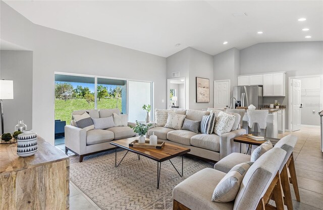 living room with high vaulted ceiling, recessed lighting, visible vents, and light tile patterned floors