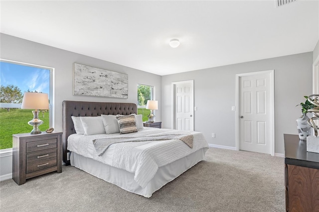 bedroom with baseboards and light colored carpet