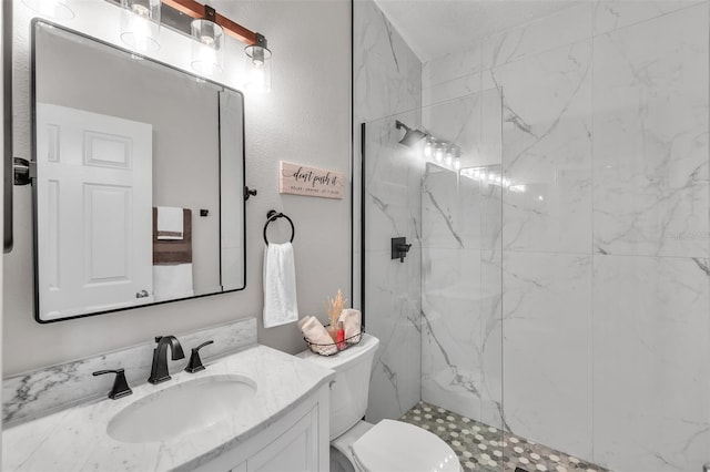 full bathroom featuring toilet, a marble finish shower, and vanity