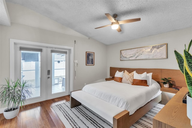 bedroom featuring french doors, vaulted ceiling, a textured ceiling, wood finished floors, and access to outside