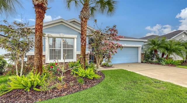 view of front of home featuring a garage, driveway, a front yard, and stucco siding