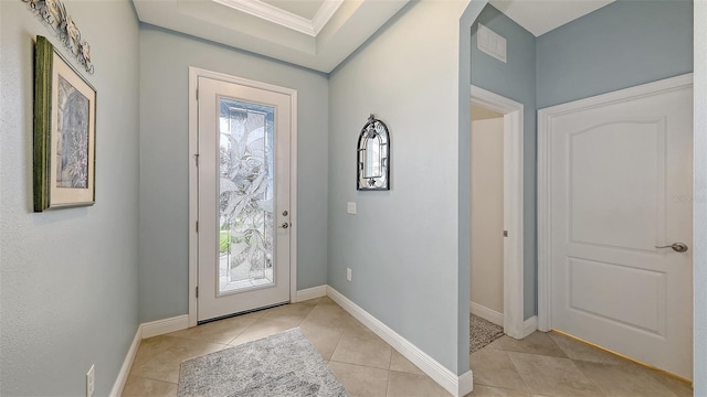 entryway with light tile patterned floors, baseboards, arched walkways, and ornamental molding