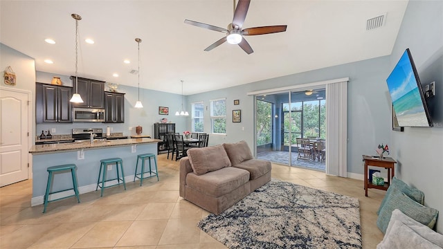 living room featuring visible vents, ceiling fan, and light tile patterned floors