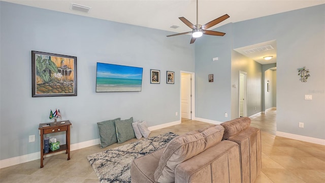 living area featuring light tile patterned floors, arched walkways, visible vents, and baseboards