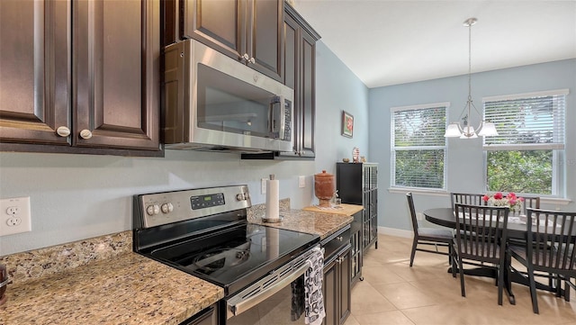 kitchen featuring decorative light fixtures, a notable chandelier, stainless steel appliances, dark brown cabinetry, and light stone countertops