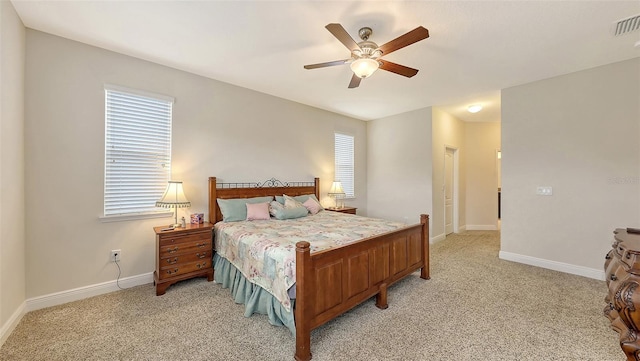 bedroom with baseboards, multiple windows, visible vents, and light colored carpet