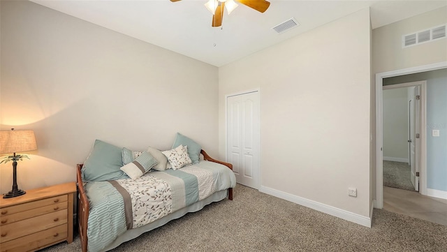 carpeted bedroom featuring ceiling fan, a closet, visible vents, and baseboards