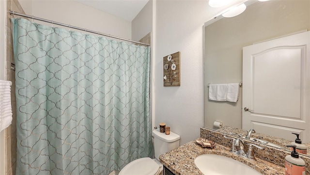 bathroom featuring curtained shower, vanity, and toilet