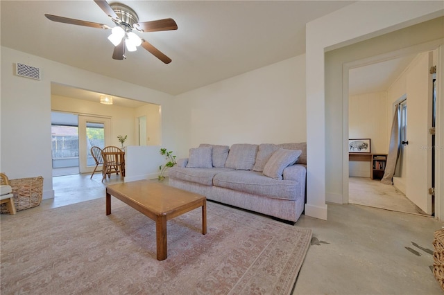 living room with concrete flooring, visible vents, and a ceiling fan