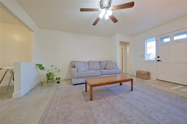 living area featuring concrete flooring and baseboards