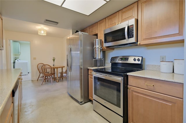 kitchen featuring washing machine and clothes dryer, stainless steel appliances, visible vents, light brown cabinetry, and concrete floors