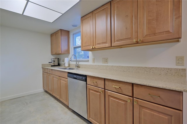 kitchen with a skylight, baseboards, light stone counters, stainless steel dishwasher, and a sink