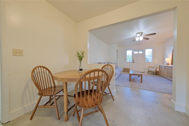 dining room featuring ceiling fan, concrete floors, and baseboards