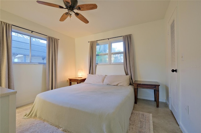 bedroom featuring baseboards, a ceiling fan, and finished concrete floors