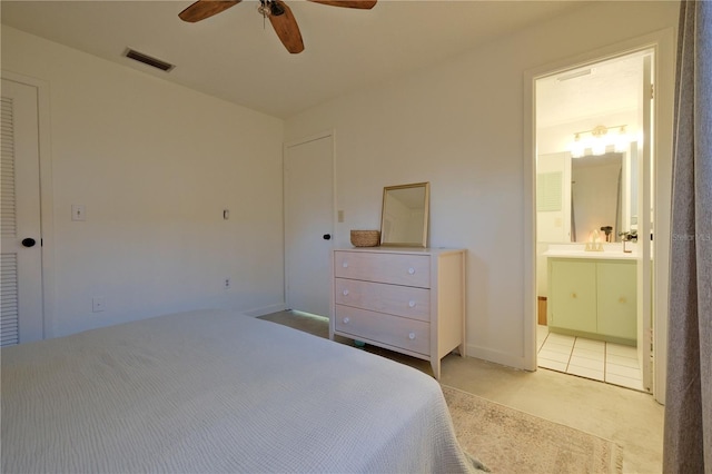 bedroom featuring visible vents, a ceiling fan, ensuite bath, carpet floors, and a sink