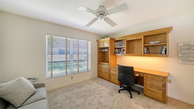 office with baseboards, a ceiling fan, and light colored carpet