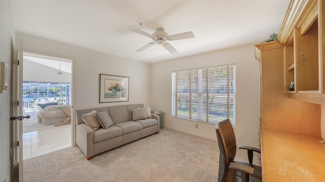 office space with a ceiling fan, light carpet, baseboards, and light tile patterned floors