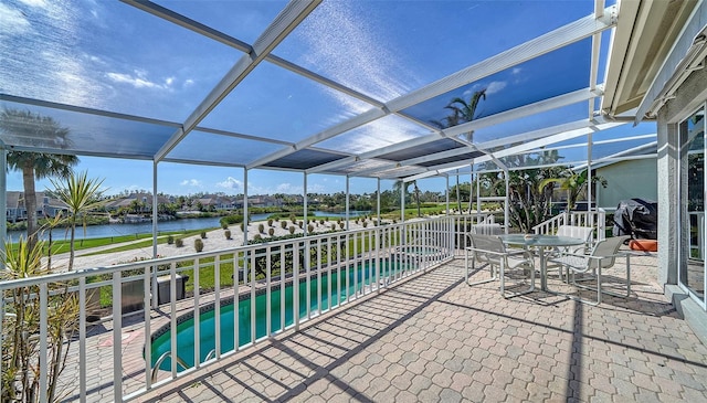 view of patio / terrace with a lanai, a water view, and an outdoor pool