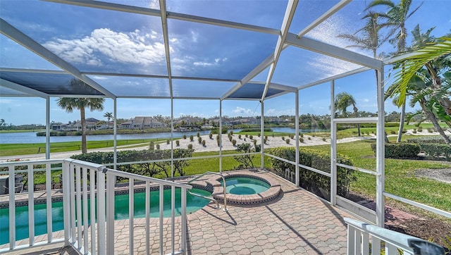 view of pool featuring a lawn, a patio, glass enclosure, a water view, and a pool with connected hot tub