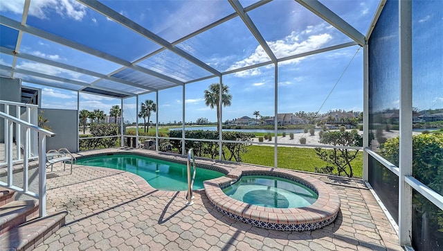 view of pool with a patio area, a pool with connected hot tub, and glass enclosure