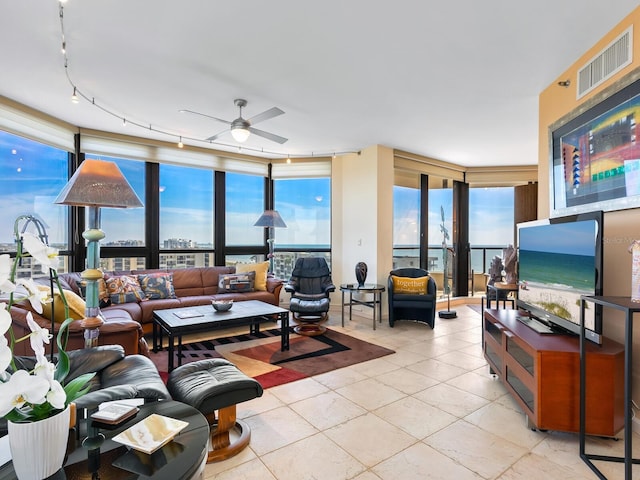 living room with a healthy amount of sunlight, floor to ceiling windows, and visible vents