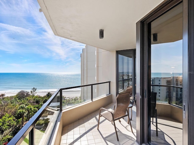 balcony featuring a water view and a beach view