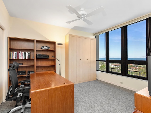 office area featuring a ceiling fan, carpet, and baseboards