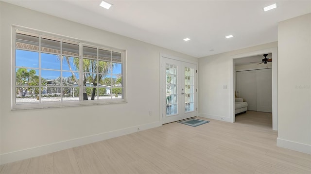 foyer entrance with baseboards, french doors, and light wood-style floors