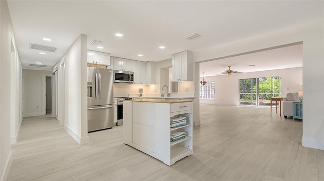 kitchen with visible vents, open floor plan, stainless steel appliances, light countertops, and open shelves