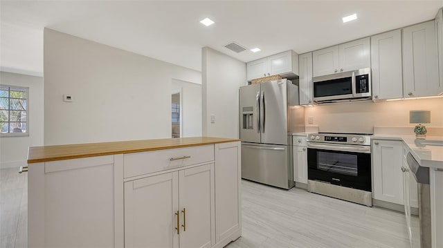 kitchen featuring white cabinetry, visible vents, stainless steel appliances, and a center island