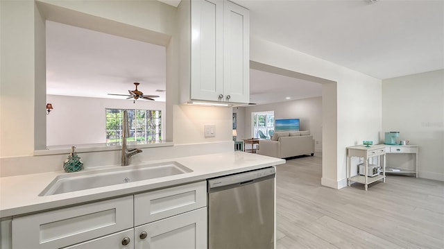 kitchen featuring a sink, a wealth of natural light, light countertops, and dishwasher