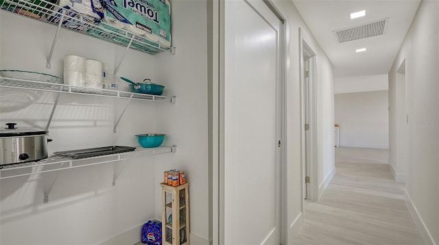 interior space featuring light wood-type flooring, baseboards, and visible vents