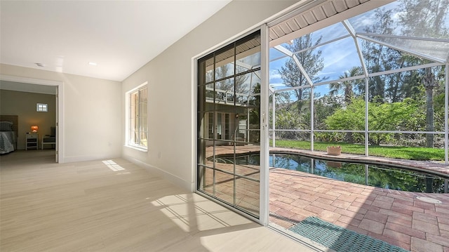 entryway featuring a healthy amount of sunlight, a sunroom, and baseboards