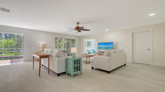 living room with recessed lighting, a ceiling fan, visible vents, baseboards, and light wood finished floors