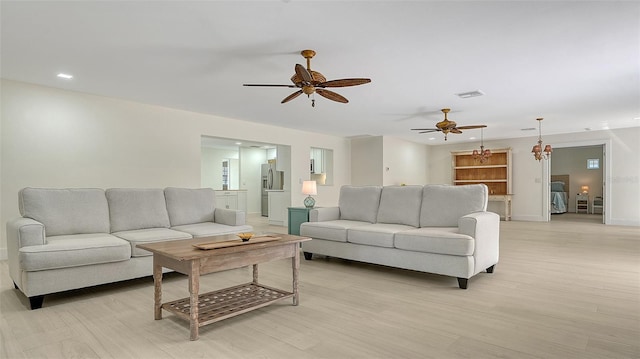 living area featuring baseboards, visible vents, a ceiling fan, light wood-style floors, and recessed lighting