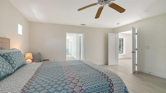 bedroom featuring light wood finished floors, baseboards, and a ceiling fan