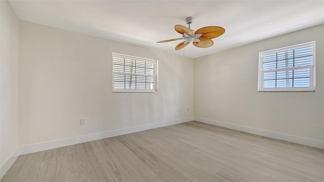 empty room with light wood-style floors, baseboards, and a ceiling fan