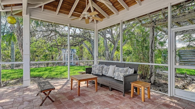 sunroom / solarium with ceiling fan, beamed ceiling, and wooden ceiling