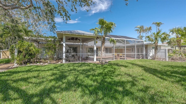 rear view of property featuring a lanai, a patio area, a lawn, and fence