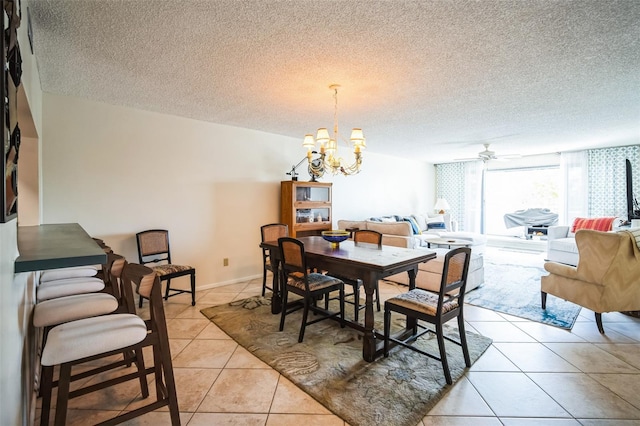 dining room featuring a textured ceiling, ceiling fan with notable chandelier, light tile patterned flooring, and baseboards