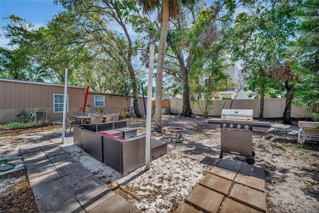 view of patio featuring a fire pit, area for grilling, and fence