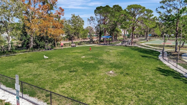 view of home's community featuring a yard and fence