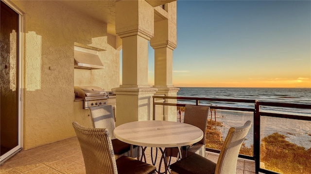 balcony with a view of the beach, a water view, and grilling area