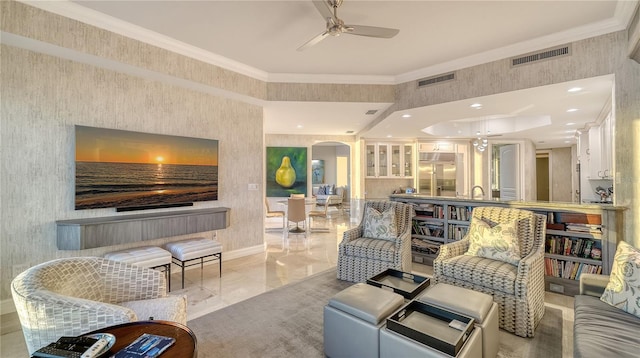 living area featuring arched walkways, visible vents, a ceiling fan, and ornamental molding