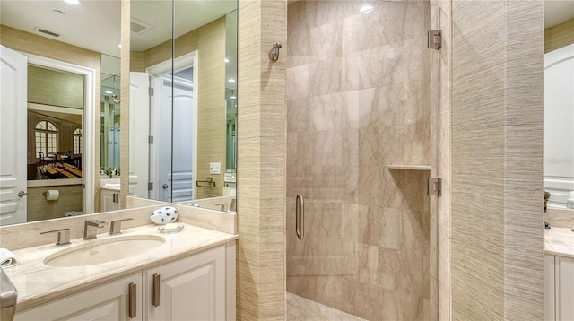 bathroom featuring visible vents, a shower stall, and vanity