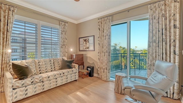 living area featuring baseboards, wood finished floors, and crown molding