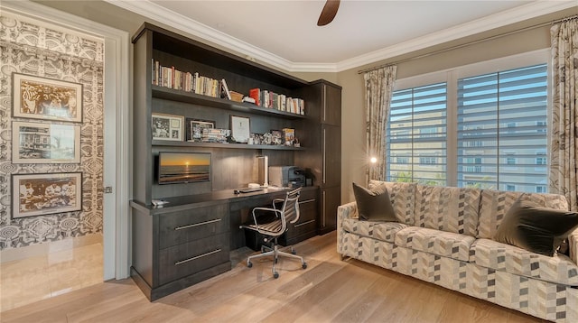 office space with light wood-style flooring, crown molding, and a ceiling fan